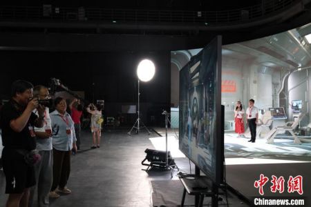 图为“行走中国·2024海外华文媒体川渝行”参访团成员在永川科技片场体验虚拟拍摄技术。李可怡 摄