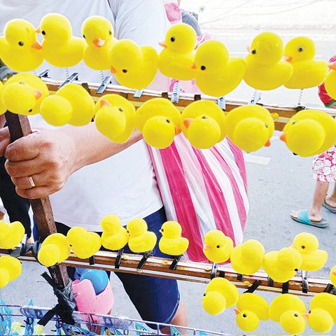 這款黃色鴨子髮夾在全國掀起熱潮，街頭巷尾都能看到民眾頭頂鴨子。圖為馬尼拉華人區小販所售賣的鴨子髮夾。