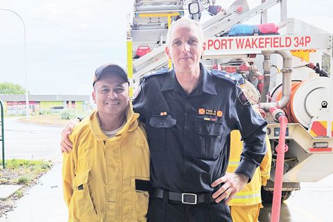 在這張來自南澳大利亞國家消防局的未註明日期的照片中，韋克菲爾德港消防中心隊長沃倫·米勒（右）和消防中心志願者薩姆森·布科爾在澳大利亞韋克菲爾德港消防站合影。2024年2月29日，菲律濱移民薩姆森·布科爾在澳大利亞議會舉行的特別會議上受到表揚布科爾幫助一個內陸小鎮維持其志願消防隊。（美聯社）