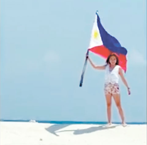 一名菲旅遊愛好者仍在南海有爭議的希望島（中業島）的一個沙洲上揮舞菲律濱國旗。（網上圖片）
