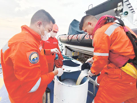 菲海岸警衛隊人員昨日在描沓安海岸收集摻雜油漬的海水。運載140萬公升工業燃油的新地號油輪週四在利邁社海上沉沒，造成大規模漏油事故。