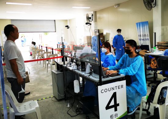 5月12日是國際護士節，在菲律濱馬尼拉某檢測中心，當值護士認真把好赴華航班旅客行前檢測關。 （中新社）