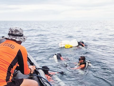 2月22日，在描絲蘭島附近海域，菲律濱海警技術潛水員進行水下作業。（新華社）