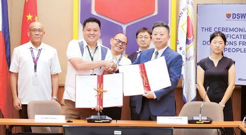 社會福利部長張僑倫與中國駐菲大使井泉簽署中國捐贈100萬美元之交接收據。