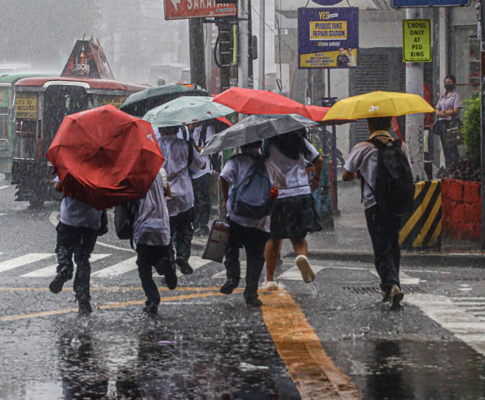 學生們8月17日在計順市的傾盆大雨中趕回家。地方政府已於下午宣布停課。